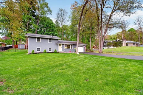 a front view of house with yard and green space