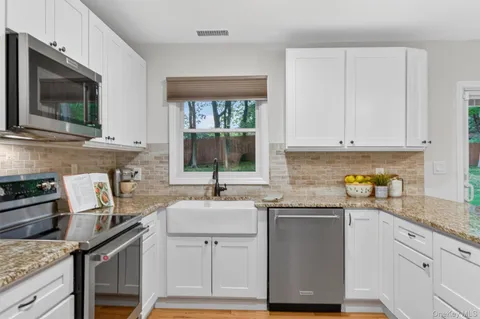 a kitchen with stainless steel appliances granite countertop a sink stove and cabinets