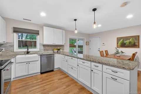 a kitchen with granite countertop white cabinets and white appliances