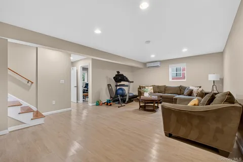 a living room with furniture and a gym machine