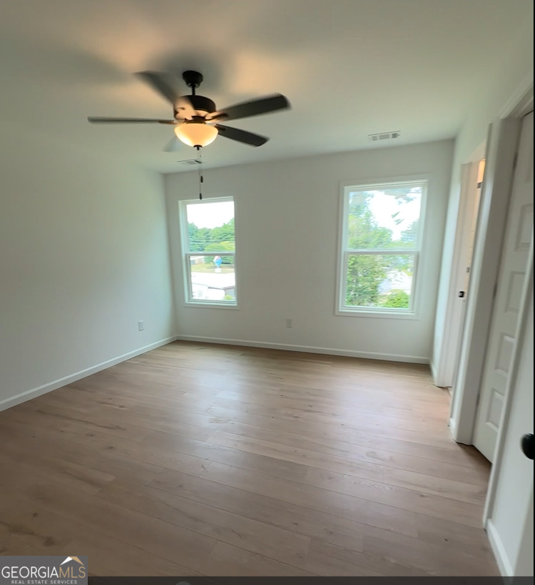 109 Burns Road Carrollton, GA 30117 - Photo 11 of 14 an empty room with windows and ceiling fan