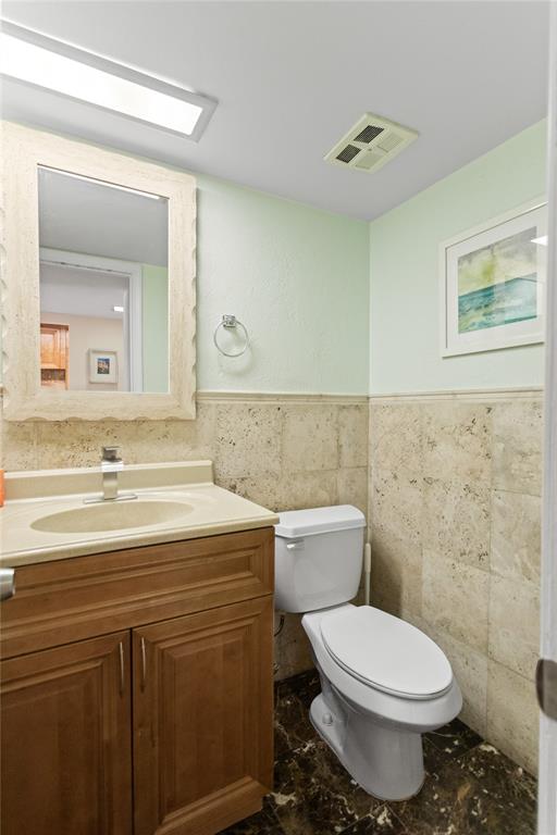 2312 South Cypress Bend Drive, Unit 205 Pompano Beach, FL 33069 - Photo 12 of 61 a bathroom with a granite countertop toilet sink and mirror
