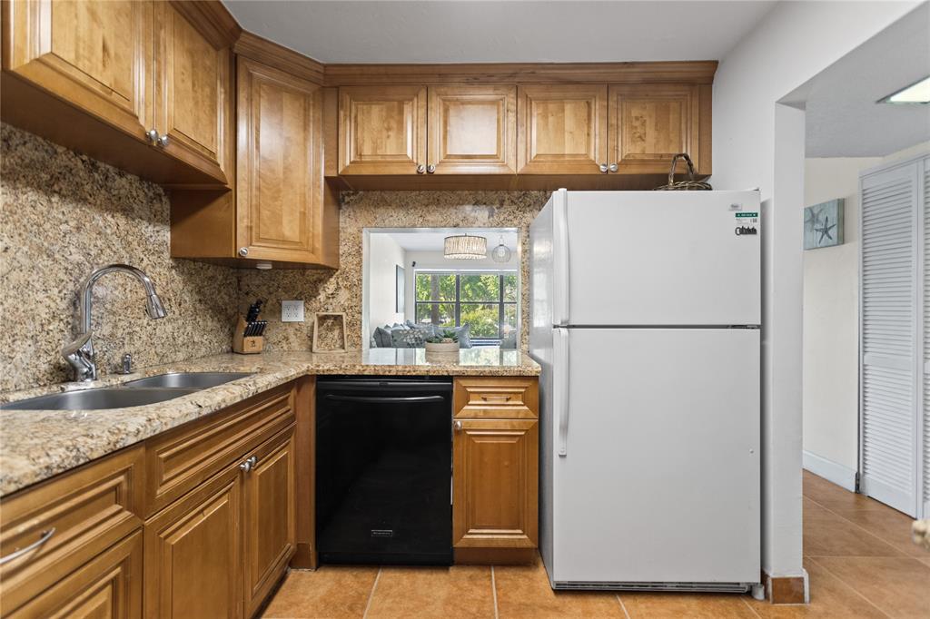 2312 South Cypress Bend Drive, Unit 205 Pompano Beach, FL 33069 - Photo 16 of 61 a kitchen with a refrigerator sink and cabinets
