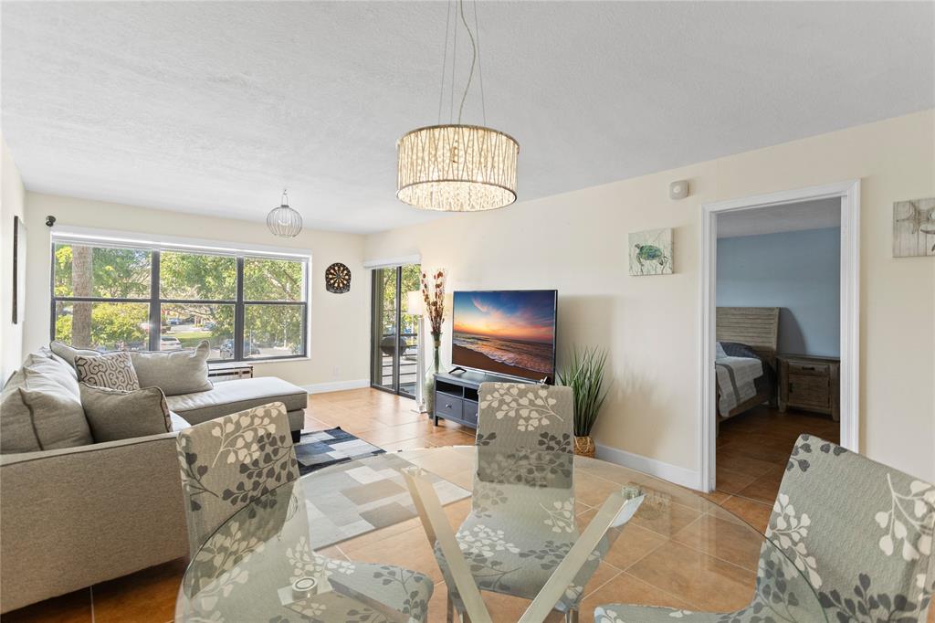 2312 South Cypress Bend Drive, Unit 205 Pompano Beach, FL 33069 - Photo 20 of 61 a living room with furniture and a flat screen tv