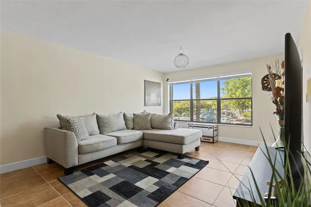 a view of a room with a floor to ceiling window and potted plants