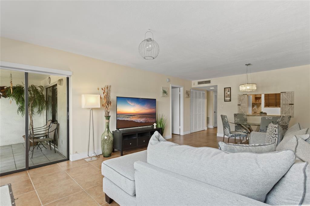 2312 South Cypress Bend Drive, Unit 205 Pompano Beach, FL 33069 - Photo 25 of 61 a living room with furniture and a flat screen tv
