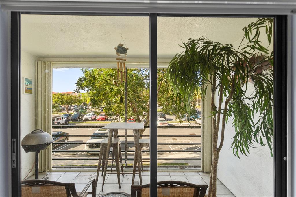 2312 South Cypress Bend Drive, Unit 205 Pompano Beach, FL 33069 - Photo 31 of 61 a view of a room with a floor to ceiling window and potted plants