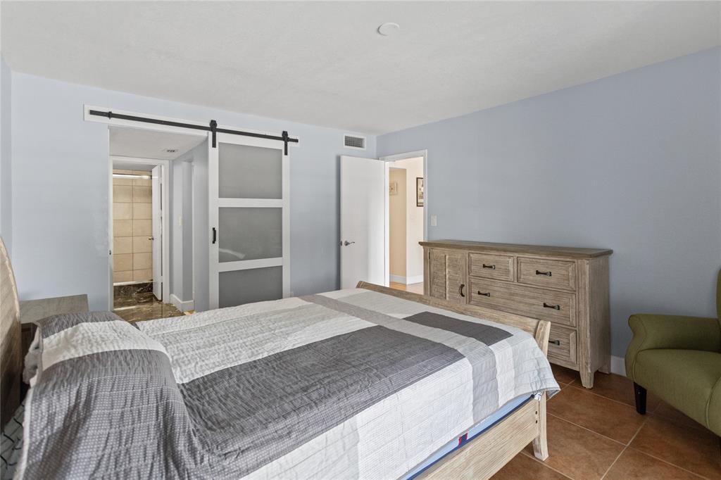 2312 South Cypress Bend Drive, Unit 205 Pompano Beach, FL 33069 - Photo 33 of 61 a bedroom with a bed and a couch