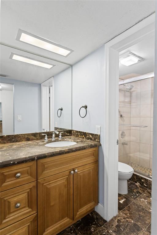 2312 South Cypress Bend Drive, Unit 205 Pompano Beach, FL 33069 - Photo 41 of 61 a bathroom with a granite countertop sink a toilet and shower