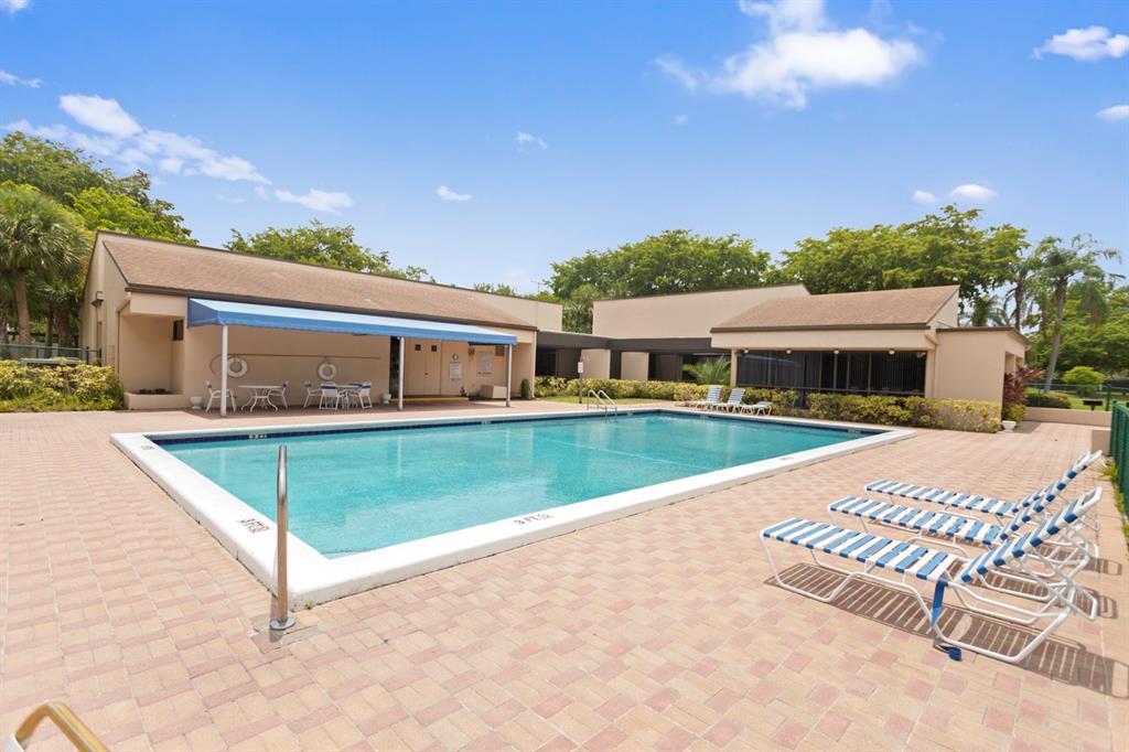 2312 South Cypress Bend Drive, Unit 205 Pompano Beach, FL 33069 - Photo 46 of 61 a view of house with swimming pool and yard