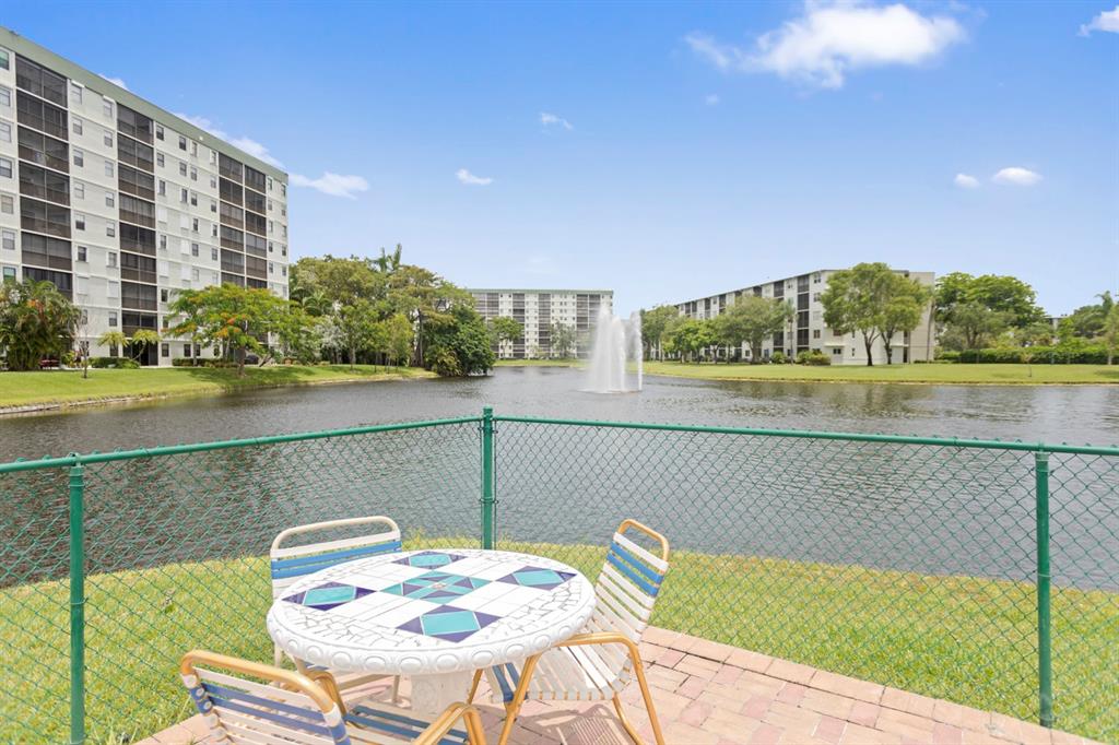 2312 South Cypress Bend Drive, Unit 205 Pompano Beach, FL 33069 - Photo 47 of 61 a view of a lake with a table and chairs