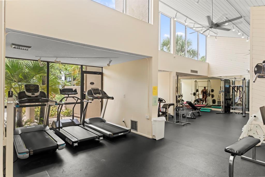 2312 South Cypress Bend Drive, Unit 205 Pompano Beach, FL 33069 - Photo 51 of 61 a room with gym equipment and large windows