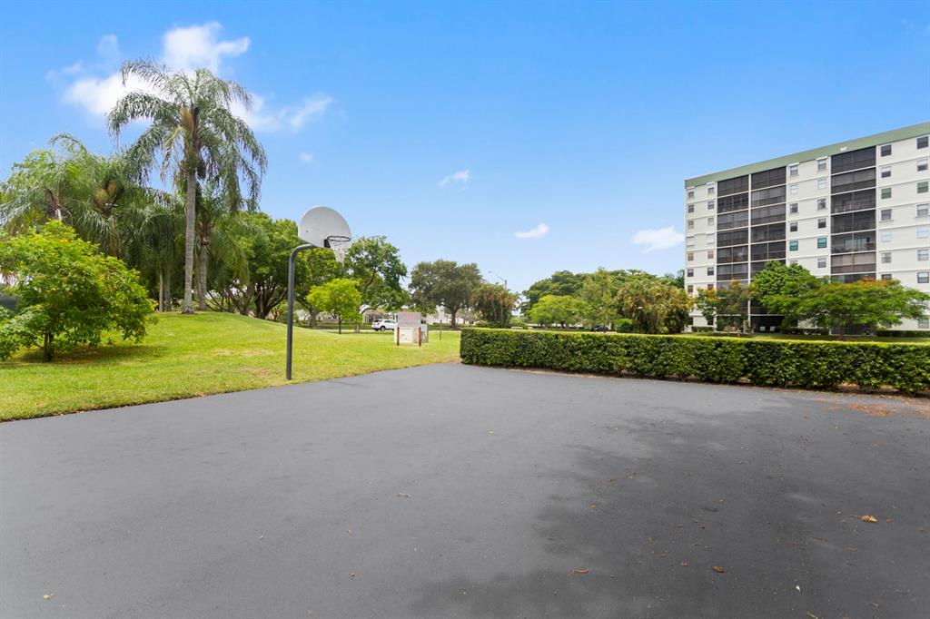 2312 South Cypress Bend Drive, Unit 205 Pompano Beach, FL 33069 - Photo 56 of 61 a view of a house with a yard and palm trees