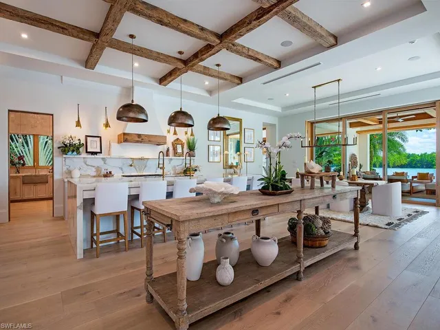 a room with stainless steel appliances kitchen island granite countertop furniture and a large window