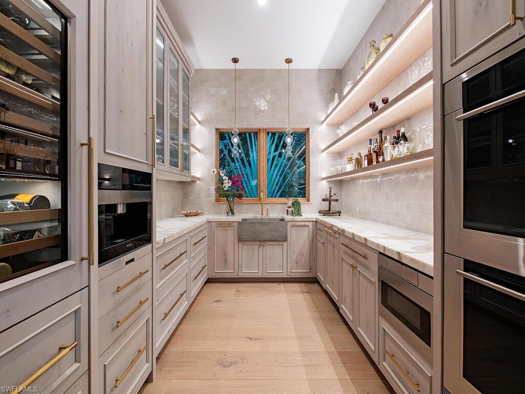 860 Admiralty Parade Naples, FL 34102 - Photo 18 of 45 a large white kitchen with stainless steel appliances granite countertop lots of counter top space and cabinets