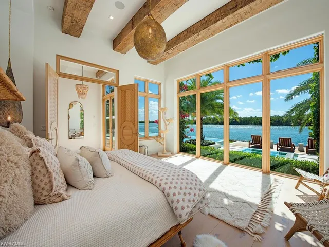 a bedroom with a bed and large windows