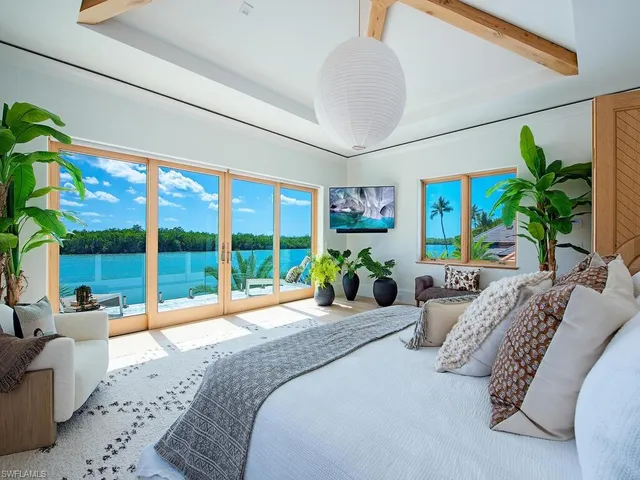 a bedroom with furniture and large windows