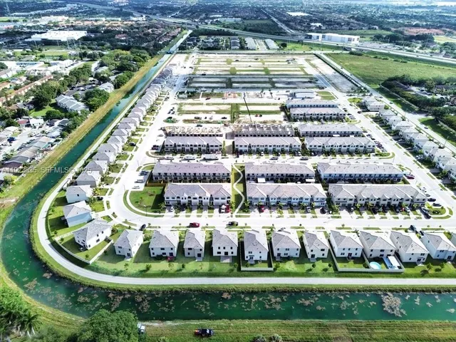 a view of a swimming pool with a yard and plants