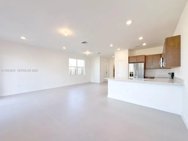 a view of a kitchen with kitchen island a sink wooden floor and glass doors