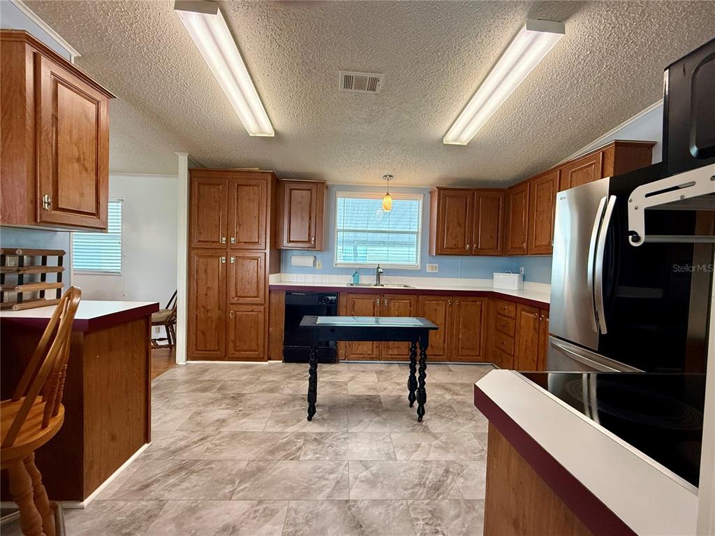 222 North St George Circle Apollo Beach, FL 33572 - Photo 8 of 33 a kitchen with stainless steel appliances a refrigerator and a stove top oven