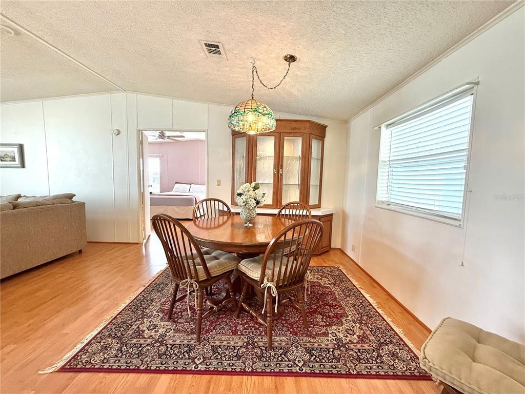 222 North St George Circle Apollo Beach, FL 33572 - Photo 9 of 33 a dining room with furniture a chandelier and wooden floor