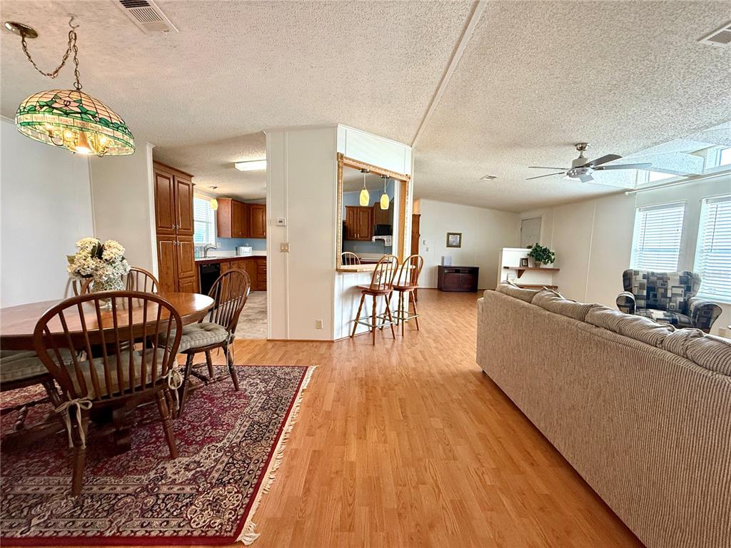 222 North St George Circle Apollo Beach, FL 33572 - Photo 10 of 33 a living room with furniture a chandelier and a dining table with wooden floor