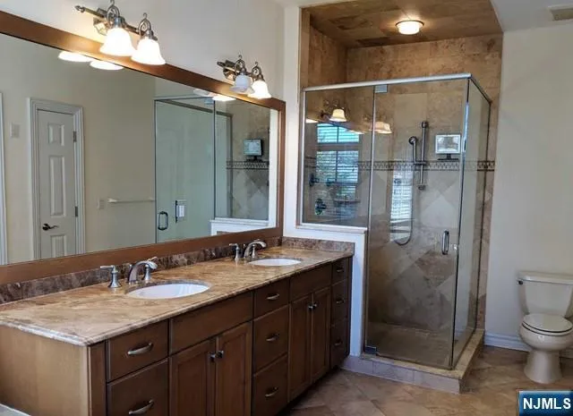 a bathroom with a granite countertop sink toilet and shower