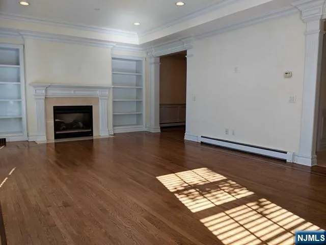 a view of a livingroom with wooden floor and a fireplace
