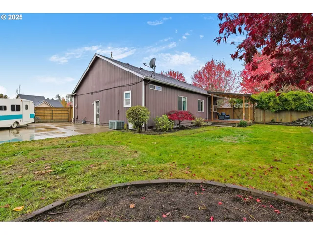 a backyard of a house with barbeque oven and car parked