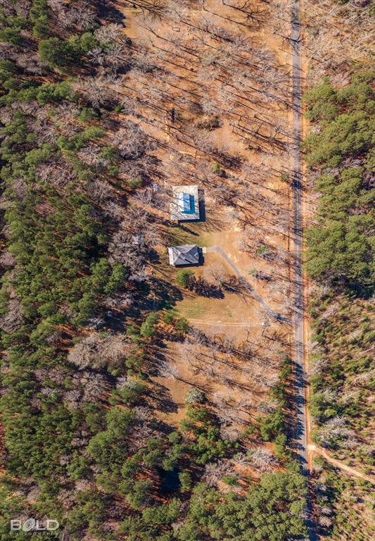 136 Scarborough Road Benton, LA 71006 - Photo 3 of 32 Aerial view showcasing two structures nestled within a wooded landscape with a defined road