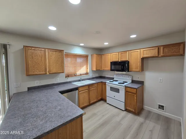 a kitchen with a sink stove top oven and refrigerator
