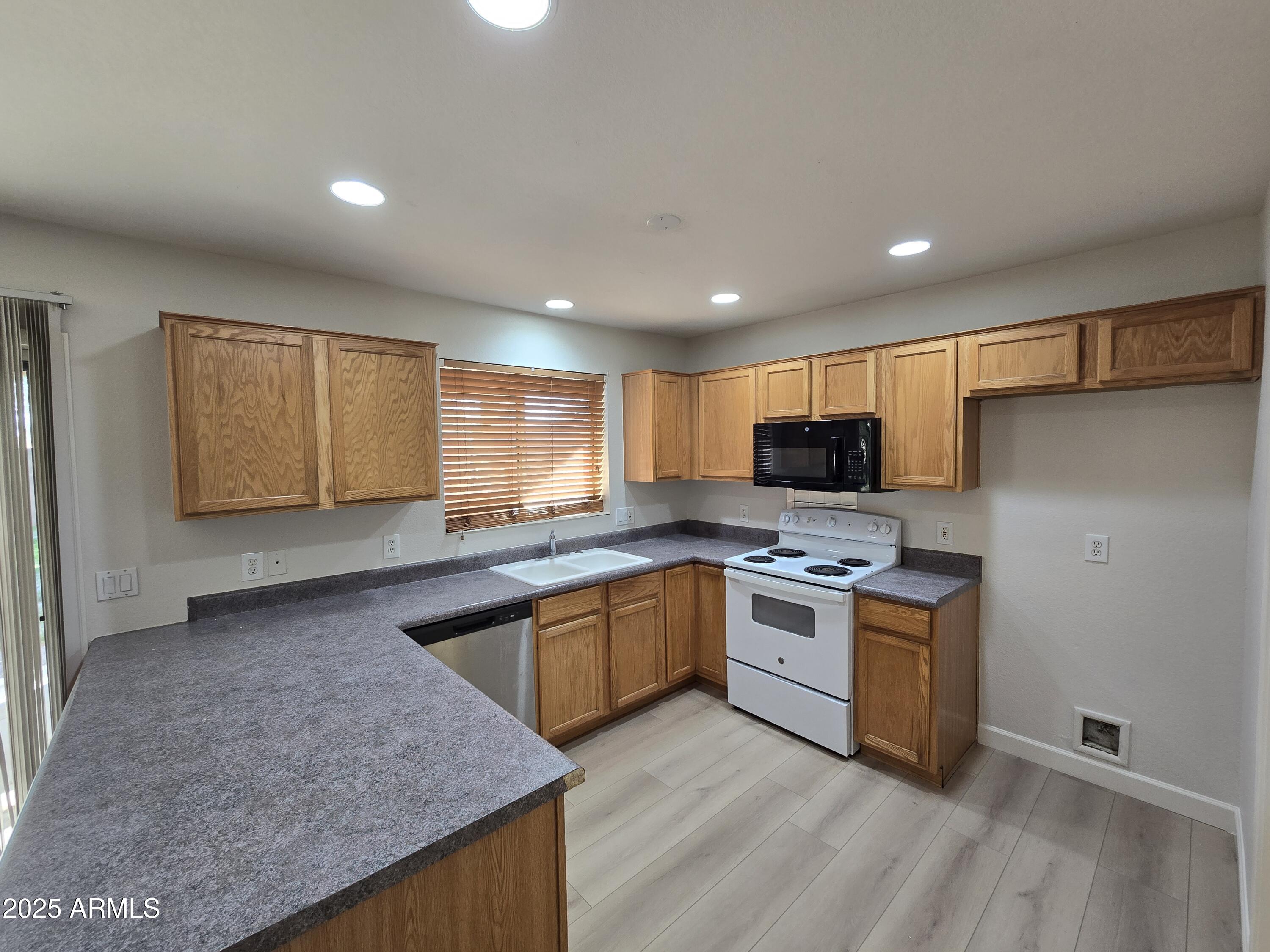 1443 West 14th Avenue Apache Junction, AZ 85120 - Photo 5 of 21 a kitchen with a sink stove top oven and refrigerator