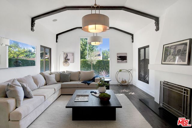 a living room with furniture fireplace and a large window