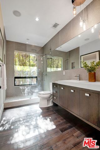 a spacious bathroom with a double vanity sink a large mirror and a window