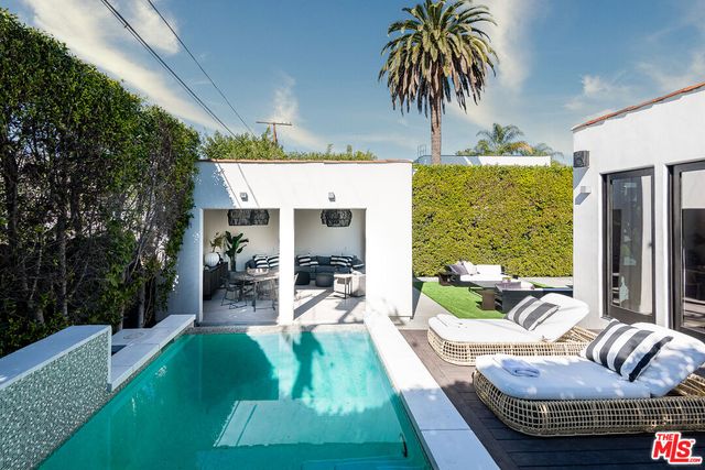 a living room with patio furniture and a large window
