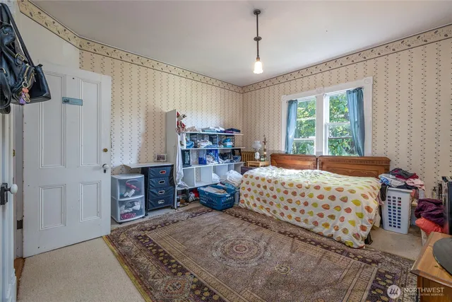 a bedroom with furniture and large windows