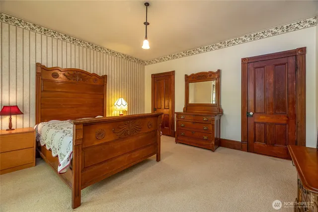a bedroom with a bed and a large mirror on the dresser