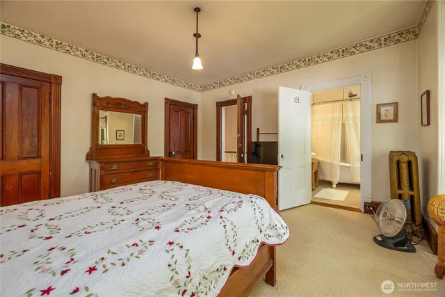 a bedroom with a large bed and a chandelier
