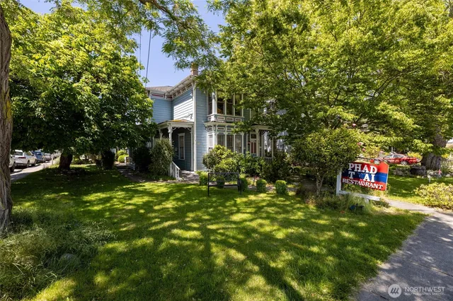 a view of a patio with table and chairs potted plants and large tree