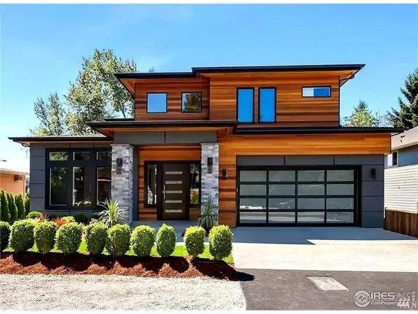 a front view of a house with a large window and potted plants