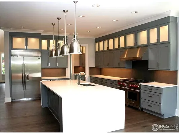 a kitchen with stainless steel appliances granite countertop a sink a stove and a refrigerator