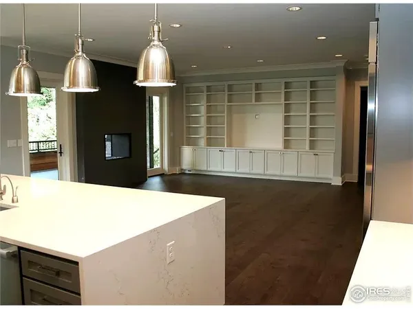 a kitchen with stainless steel appliances a sink a counter space and a view of living room