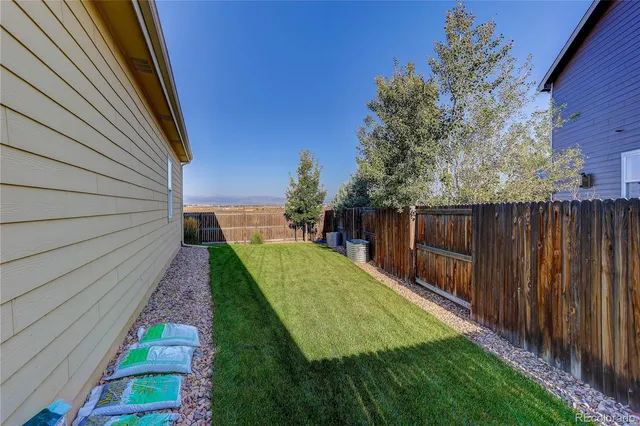 a view of a backyard with wooden fence
