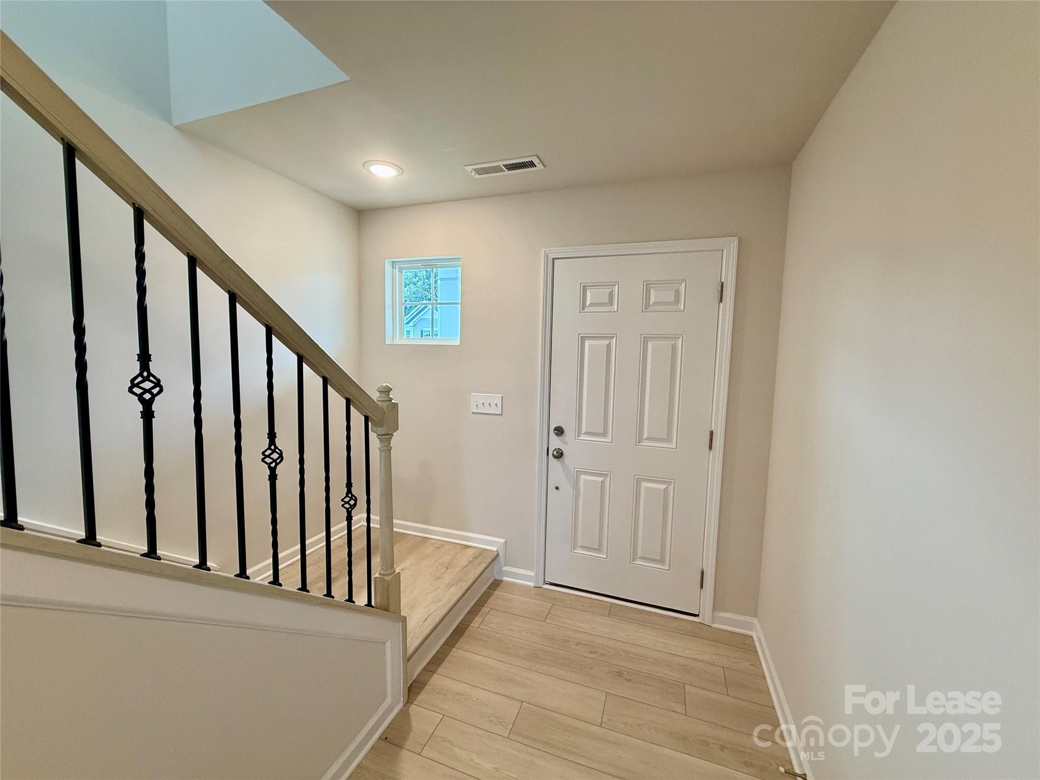 117 Dorian Place Troutman, NC 28166 - Photo 4 of 31 a view of a hallway with wooden floor and staircase