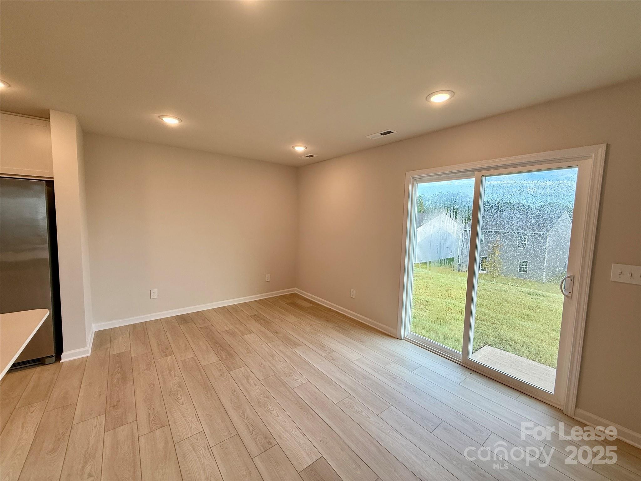 117 Dorian Place Troutman, NC 28166 - Photo 8 of 31 a view of an empty room with wooden floor and a window