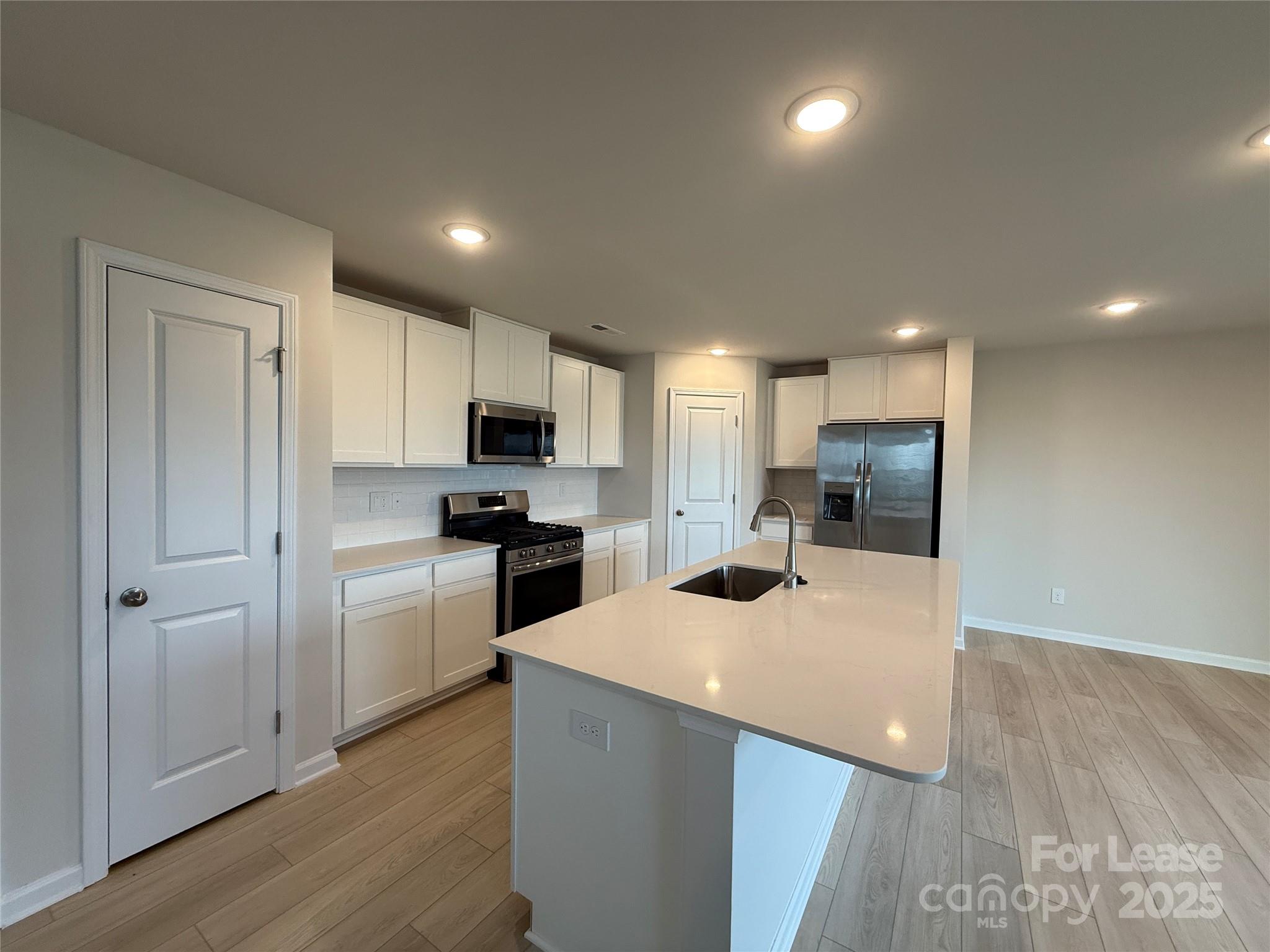 117 Dorian Place Troutman, NC 28166 - Photo 10 of 31 a kitchen with a refrigerator a microwave and cabinets