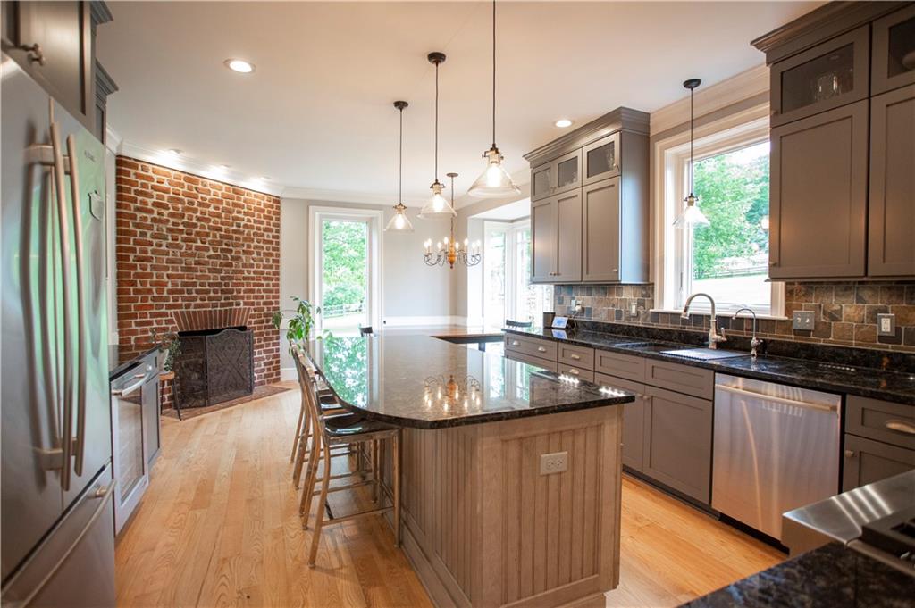 255 Camp Run Road Harmony, PA 16037 - Photo 12 of 49 a kitchen with stainless steel appliances granite countertop a stove a sink dishwasher a microwave oven and a dining table with wooden floor