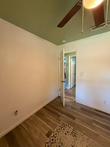 a spacious bedroom with a bed and ceiling fan