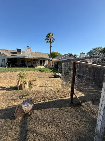 a view of a backyard with a table and chairs with wooden fence