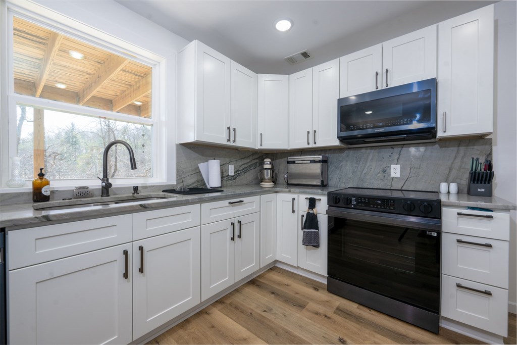 3160 Morrow Road Murphy, NC 28906 - Photo 22 of 44 a kitchen with granite countertop a stove a sink and a microwave